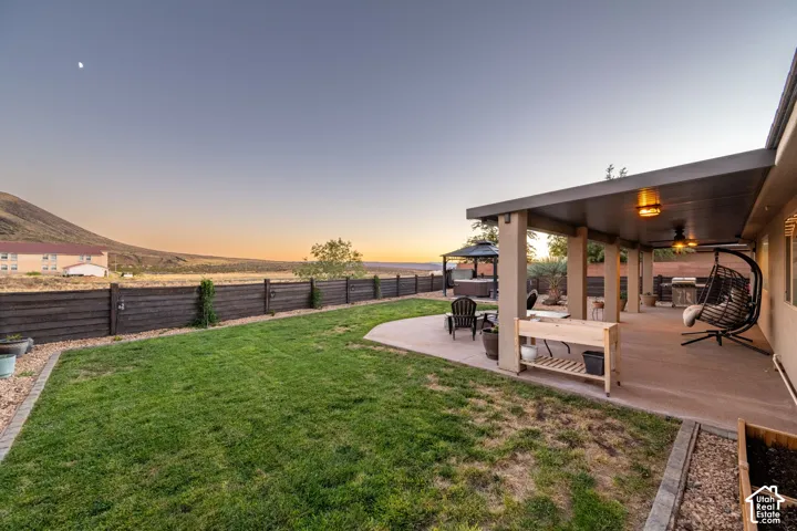 Expansive outdoor living area featuring a covered patio, a separate patio with a gazebo, and a manicured lawn