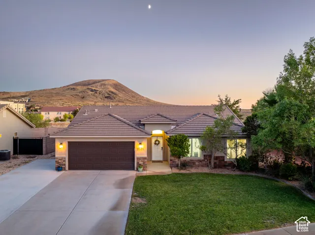 Single-story residence featuring a tile roof, an integrated two-car garage, and stone accents