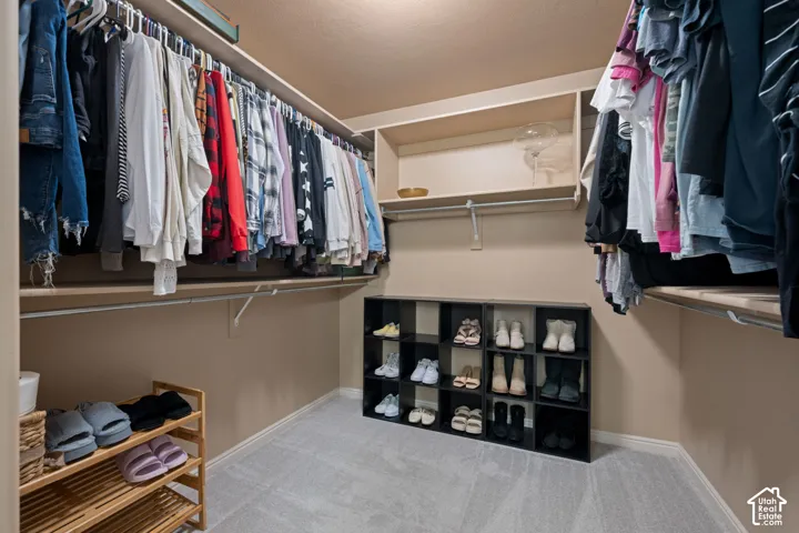 Wall-to-wall carpeting with built-in shelving, hanging rods, and ample storage space