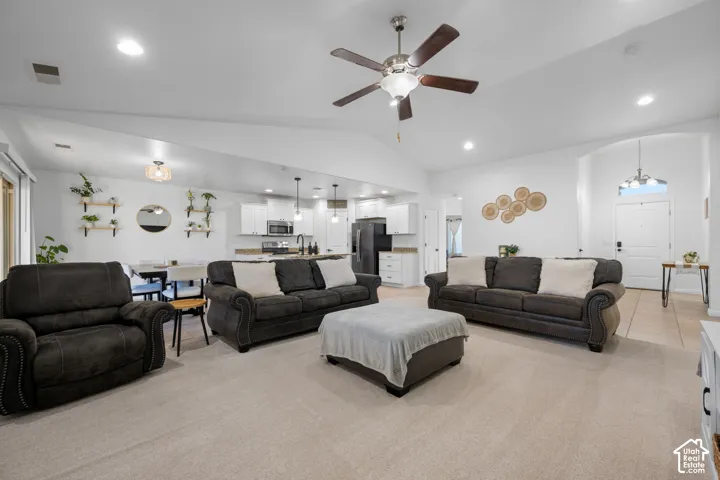 Vaulted ceilings with recessed lighting, ceiling fan, and light-toned carpet