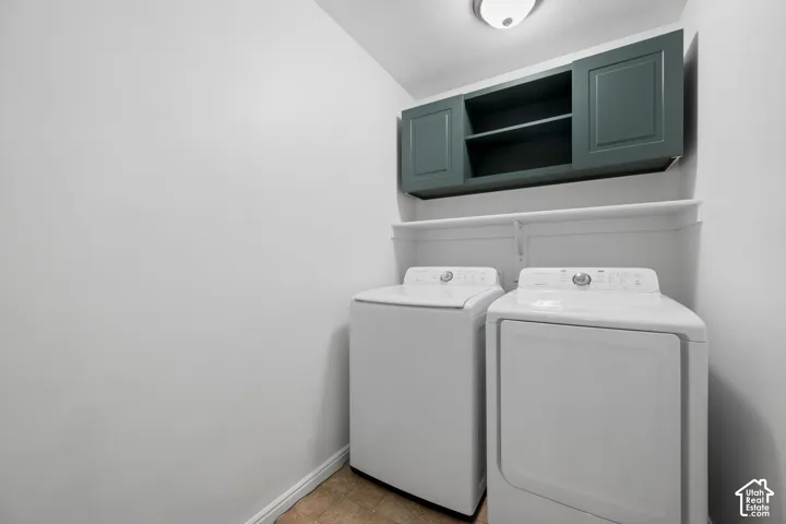 Laundry area featuring overhead cabinetry, wall shelving, and resilient flooring
