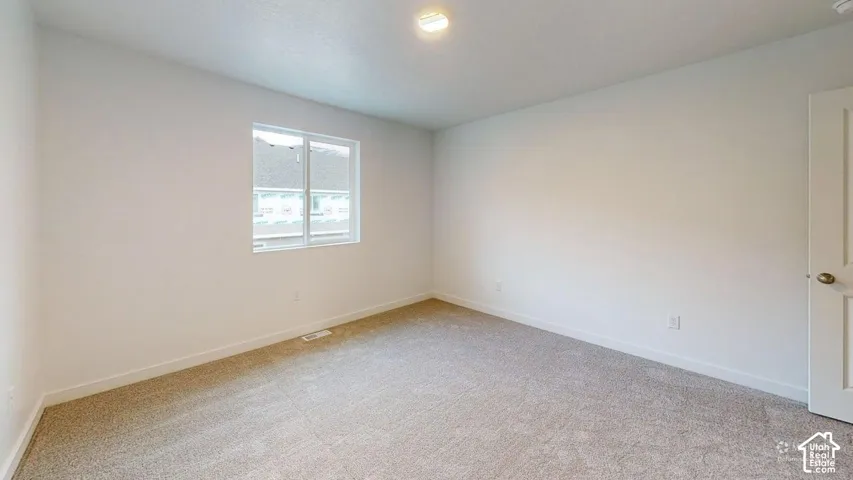 Recessed lighting, light-colored carpeting, white interior walls, white trim, and a white interior door