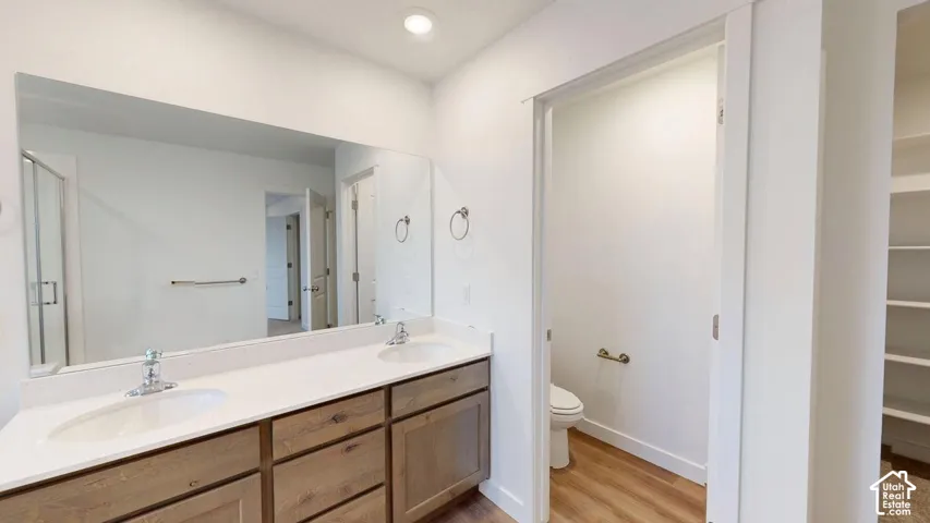 Dual vanity with undermount sinks, light-toned countertops, and wood-finish cabinetry