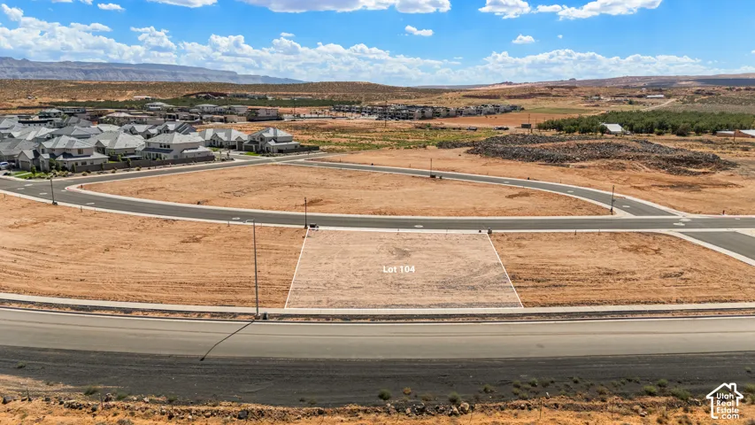 Cleared lot with marked boundaries, surrounded by paved roadways and sidewalks