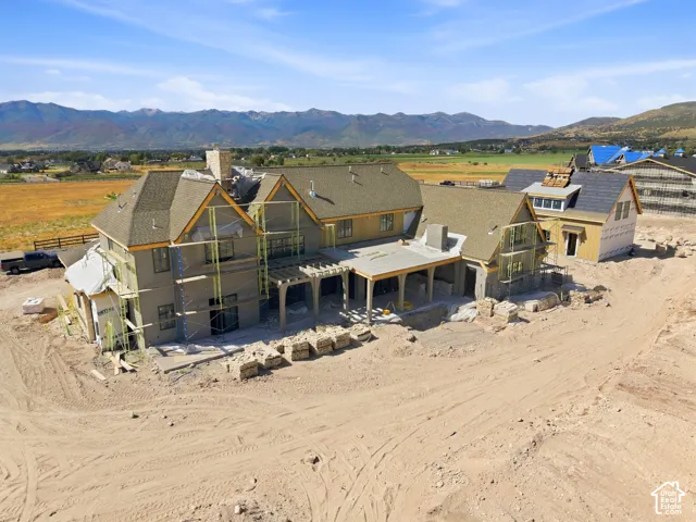 Multi-level residence under construction with a stone chimney and varied rooflines