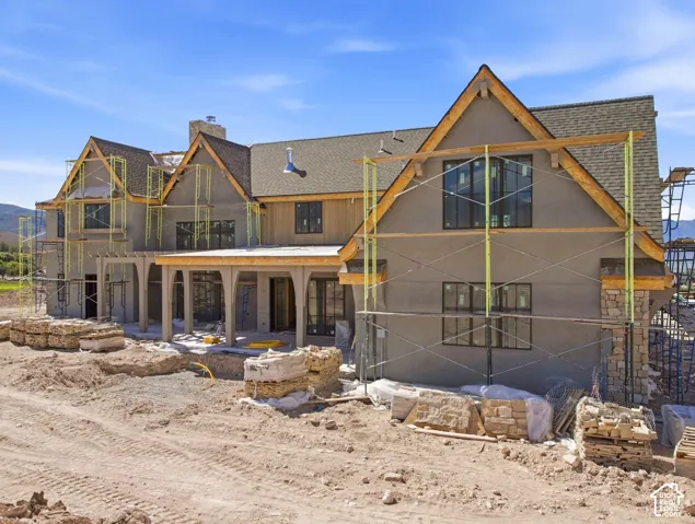 Contemporary exterior with multiple gables, stone accents, and a covered patio featuring arched supports