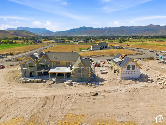 New construction with an unfinished exterior, a partially shingled roof, and an exposed rear patio with a pergola