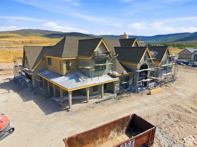 Multiple gabled rooflines, stone veneer accents, and a covered porch structure
