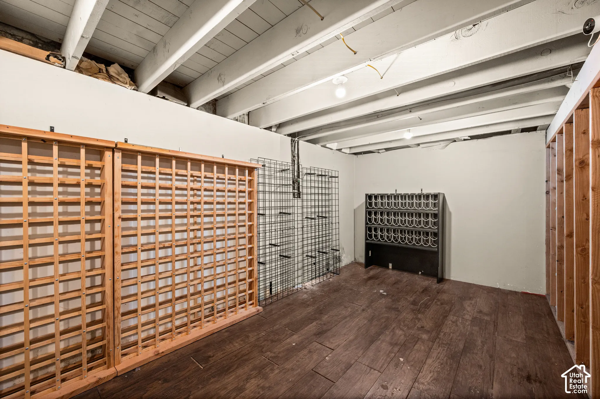 Exposed ceiling joists and beams, wood-finish flooring, and built-in wine storage