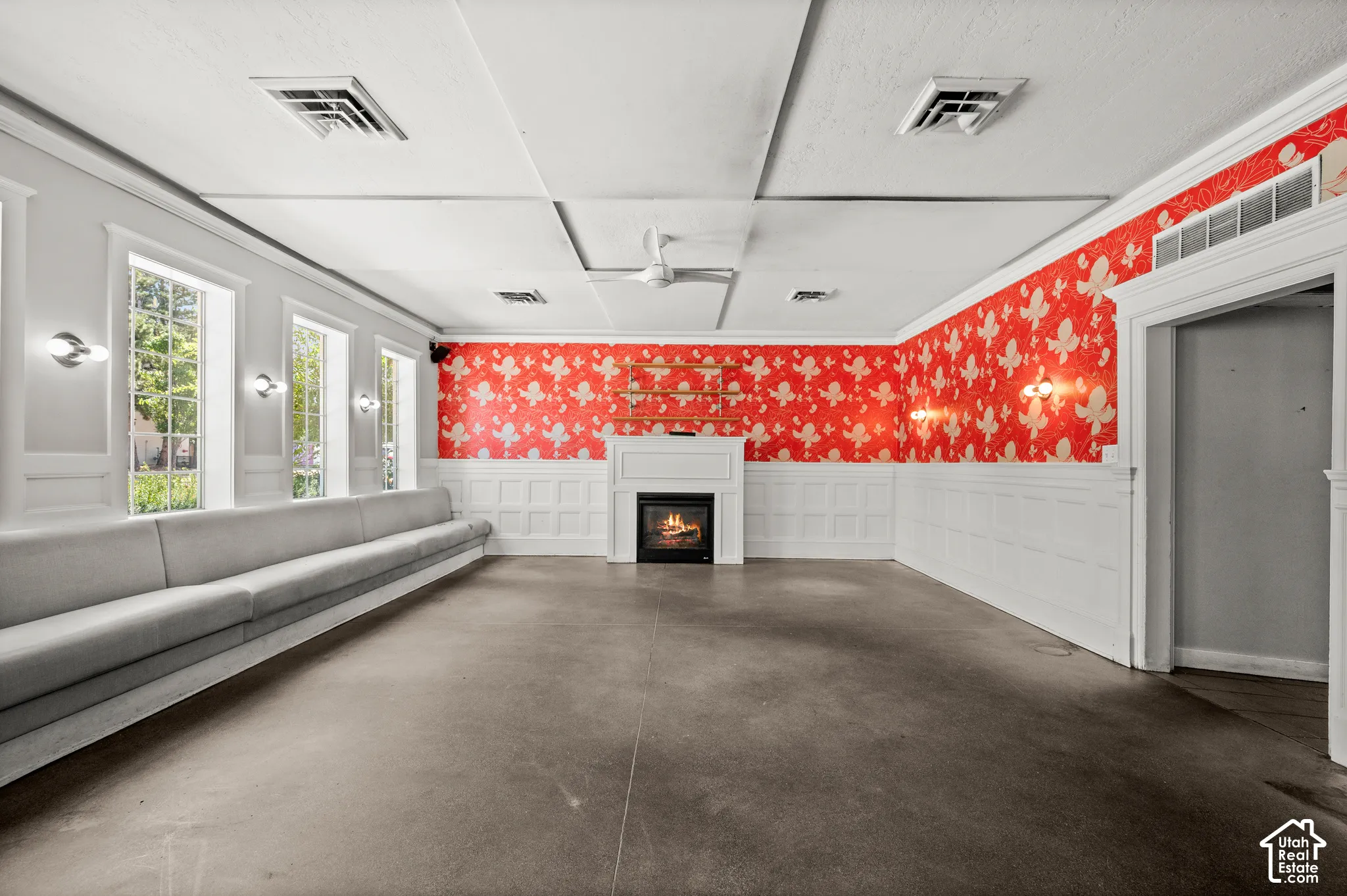 White wainscoting with decorative paneling, a built-in fireplace, multiple tall windows, and recessed lighting