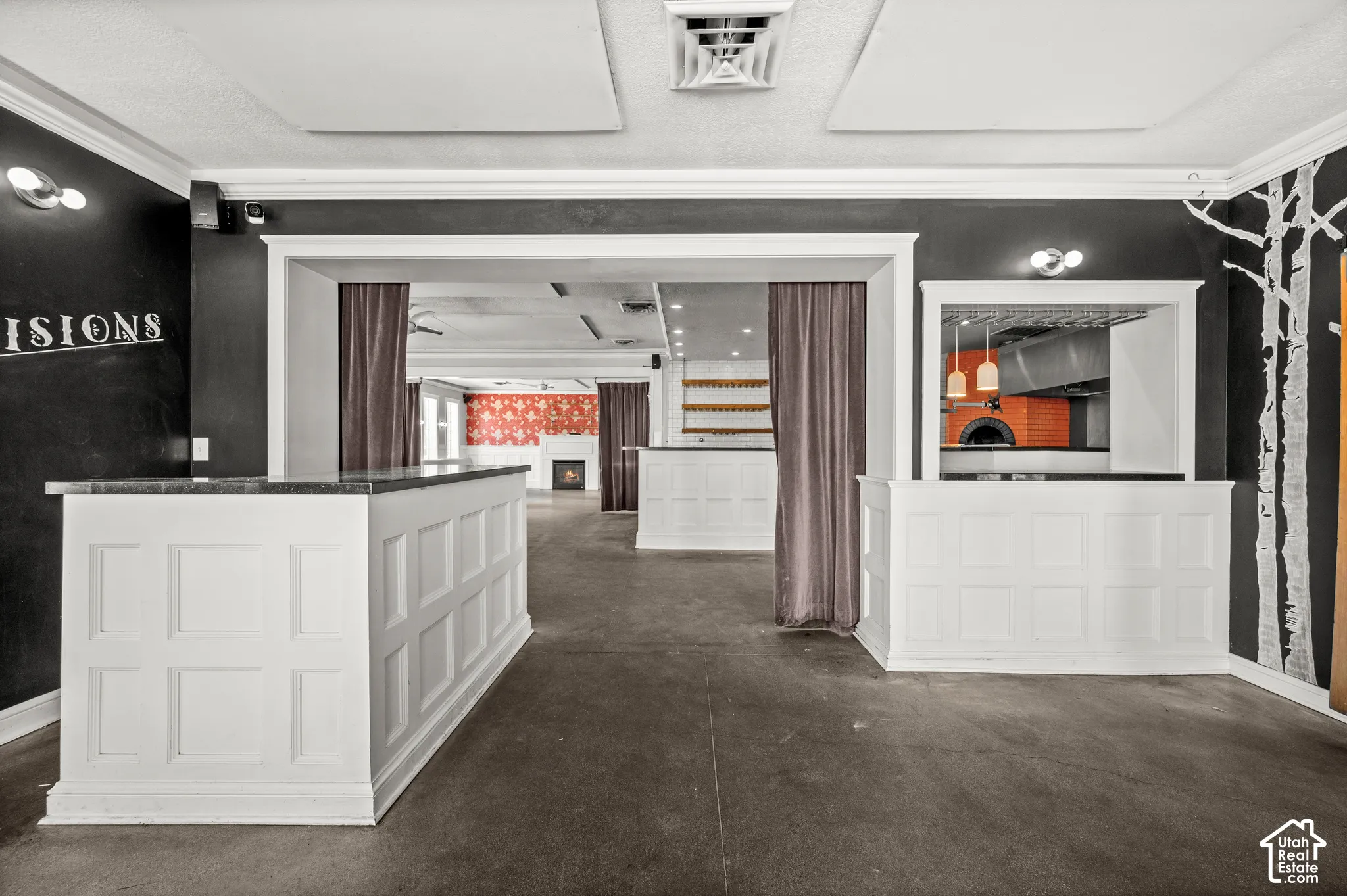 White paneled bar areas with dark countertops, a built-in brick oven, recessed lighting, and a decorative tree-themed wall graphic