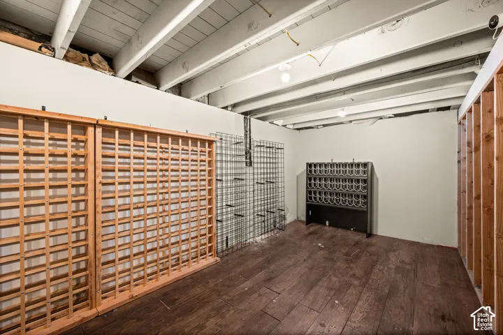 Exposed ceiling joists and beams, wood-finish flooring, and built-in wine storage