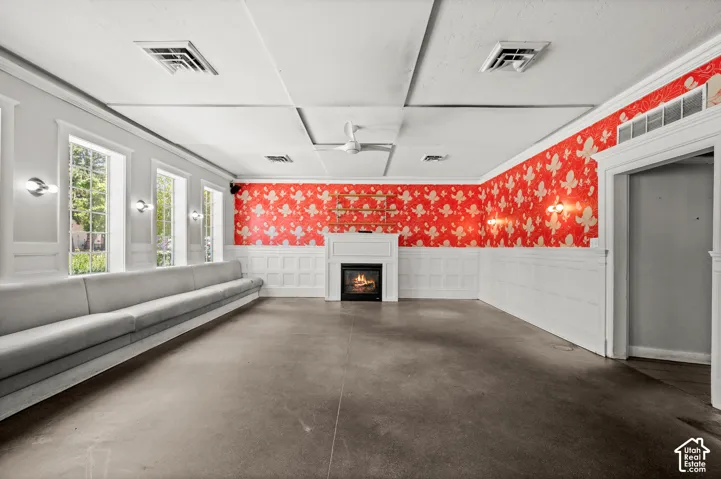 White wainscoting with decorative paneling, a built-in fireplace, multiple tall windows, and recessed lighting