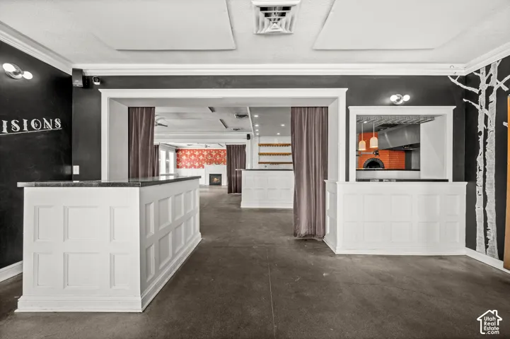 White paneled bar areas with dark countertops, a built-in brick oven, recessed lighting, and a decorative tree-themed wall graphic
