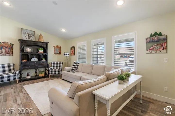Wood-finish flooring, recessed lighting, and multiple windows with horizontal blinds