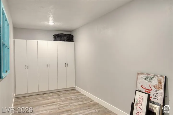 Wall-to-wall built-in cabinetry with modern hardware, wood-finish flooring, and recessed ceiling lighting