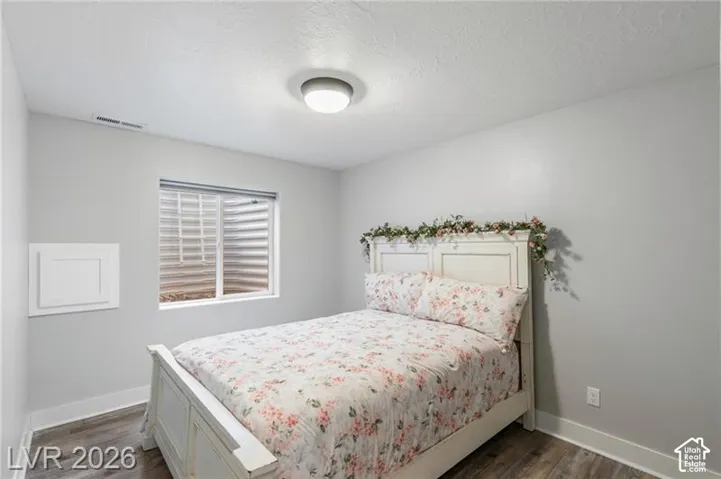 Recessed window with a window well, wood-finish flooring, and a flush mount ceiling light fixture