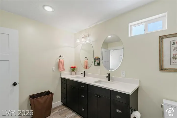 Dual vanity with dark wood-finish cabinetry and white countertops