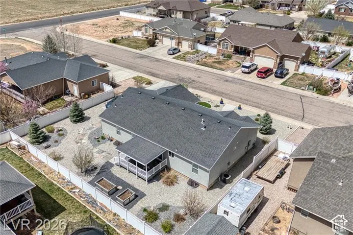 Rear exterior with a covered porch, gravel landscaping, and a white privacy fence