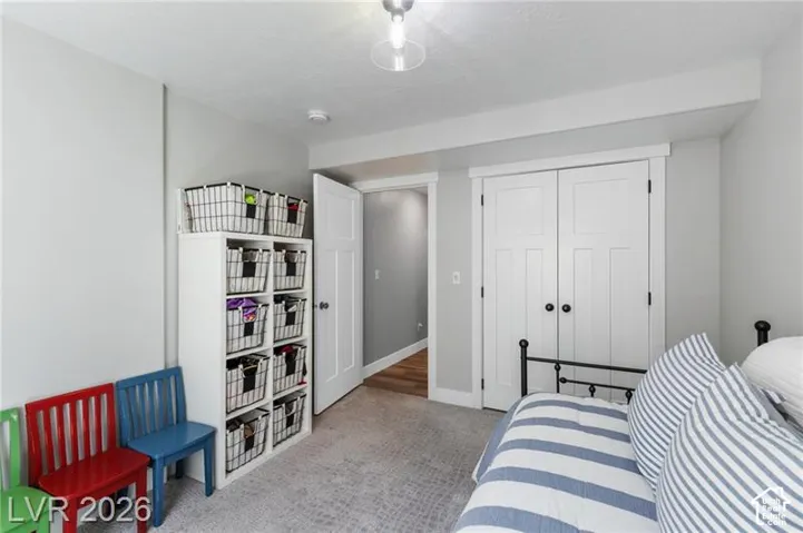 White paneled closet doors, light gray wall finishes, and a neutral carpeted floor