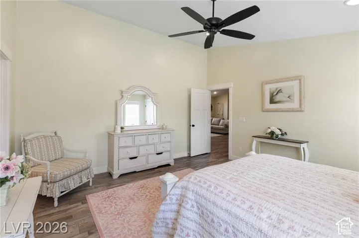 Vaulted ceiling, wood-finish flooring, ceiling fan, and white interior doors