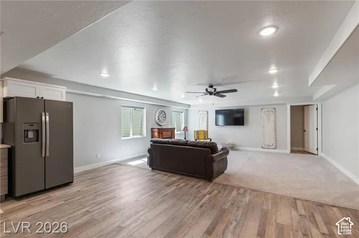 Recessed ceiling lighting, wood-finish flooring, two windows, ceiling fan, and built-in cabinetry