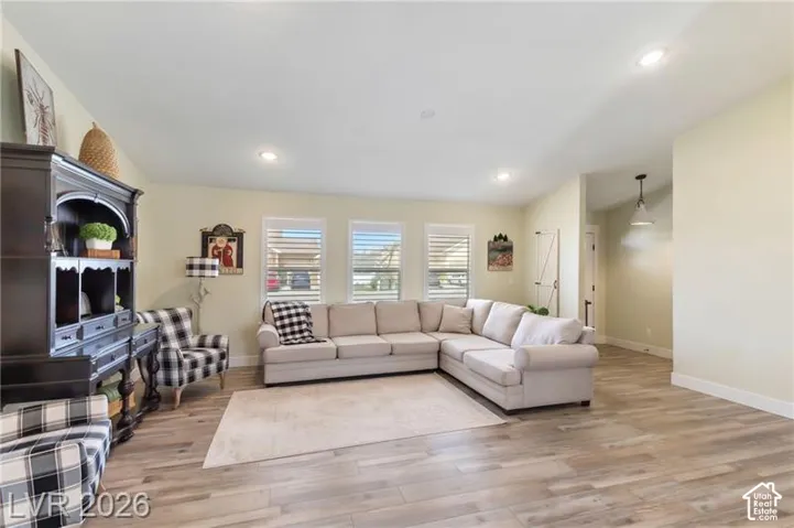 Wood-finish flooring throughout, recessed lighting, and multiple windows with horizontal blinds