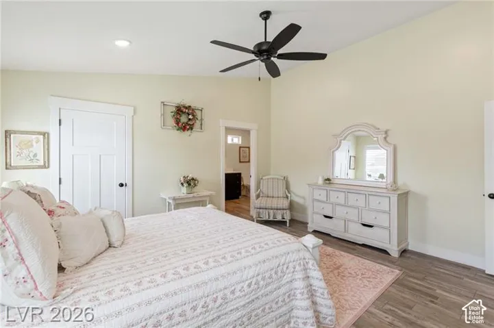 Vaulted ceiling with a ceiling fan, recessed lighting, wood-finish flooring, and a flat-panel interior door with dark hardware