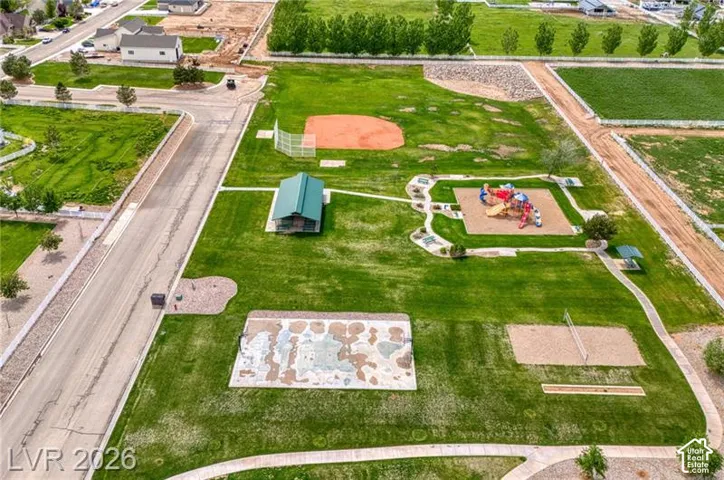 Expansive green space featuring a baseball diamond, playground area, and a volleyball court