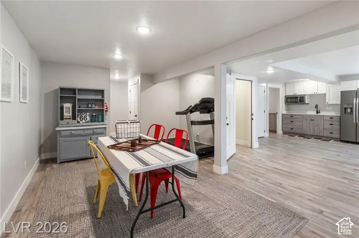 Open-concept living space with recessed lighting, wood-finish flooring, and a full kitchen featuring stainless steel appliances