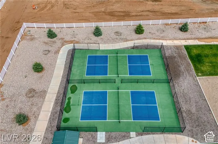 Two pickleball courts with black perimeter fencing