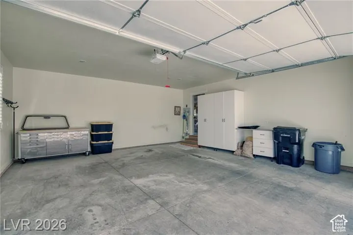 Garage featuring a concrete floor, overhead door, and recessed lighting