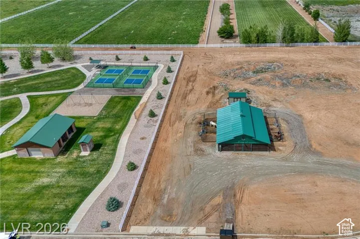 Expansive property featuring a large barn, multiple tennis courts, a dedicated play area, and an additional structure with a green roof