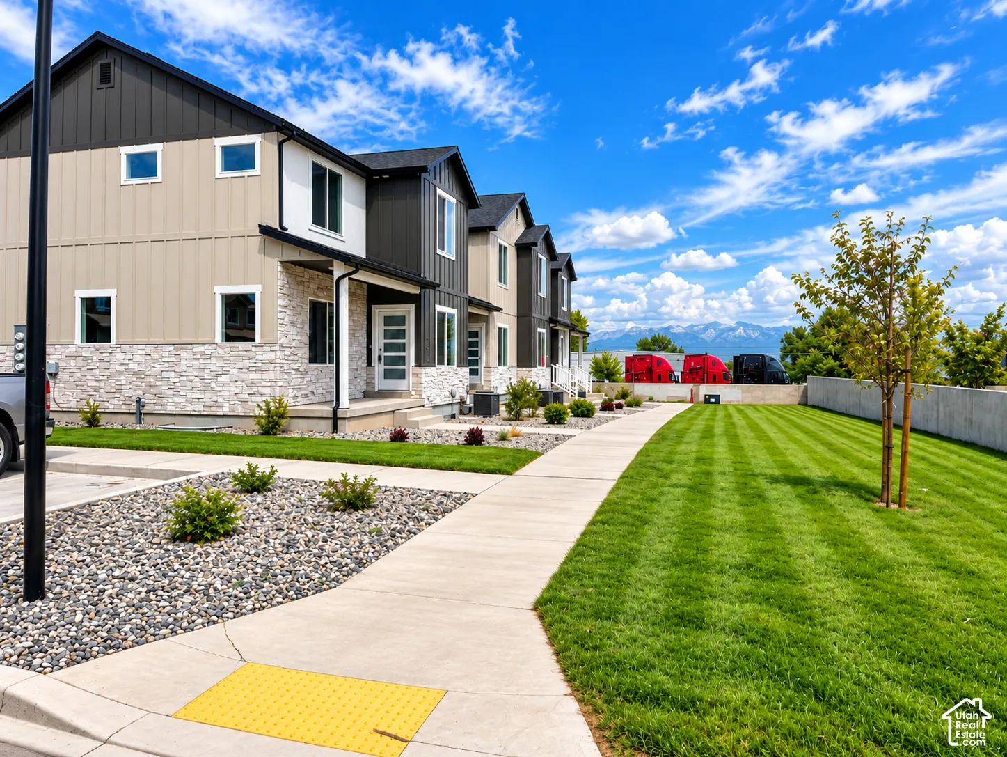 Contemporary townhome with a mixed material exterior featuring stone, vertical siding, and horizontal siding
