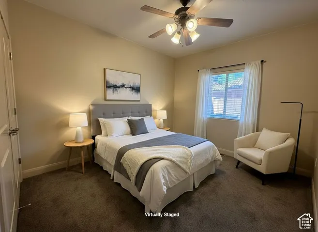 Carpeted flooring, window with blinds, ceiling fan with light fixture, and a paneled door