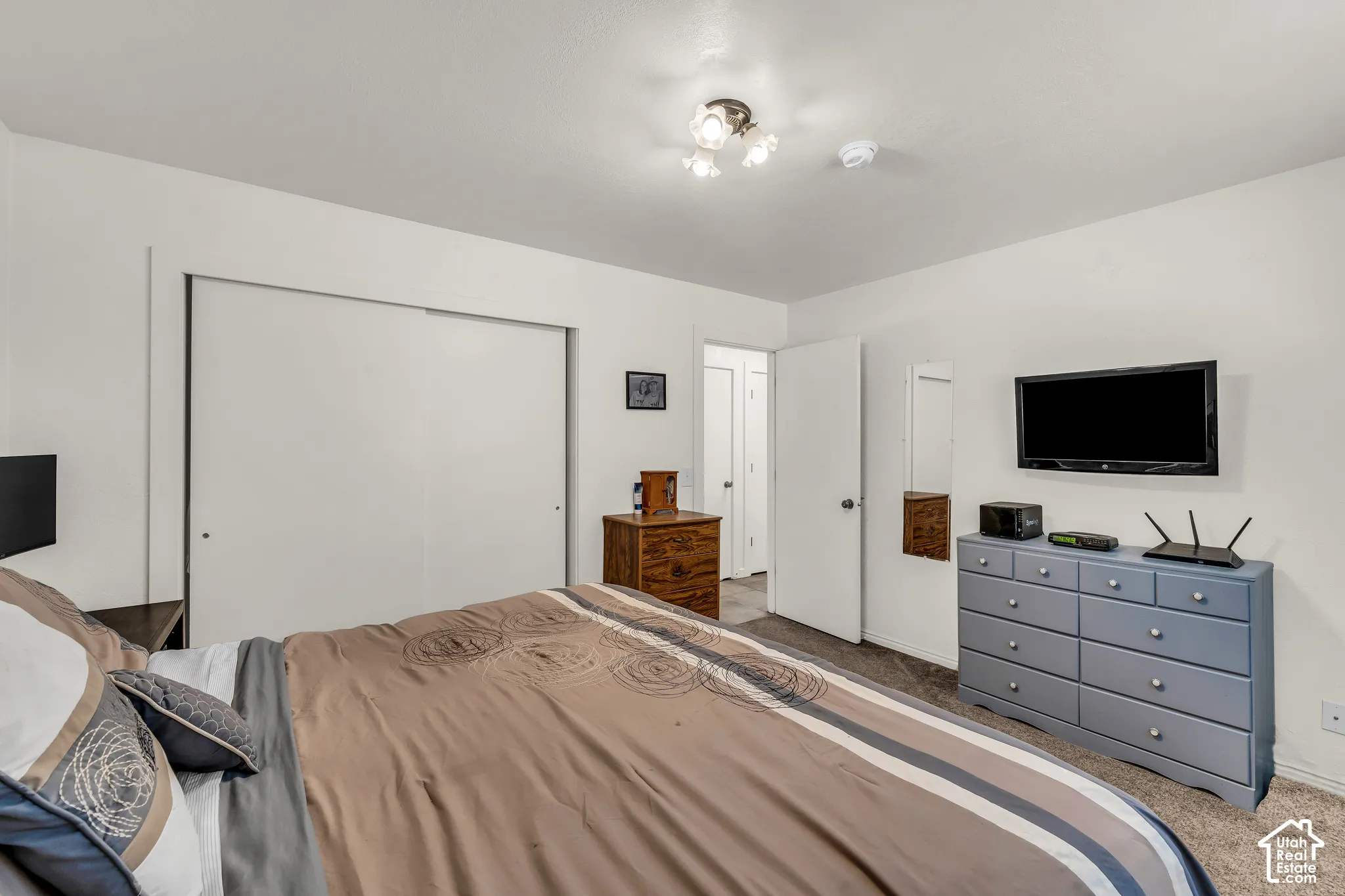 Wall-to-wall carpeting, white closet doors, and a ceiling-mounted light fixture