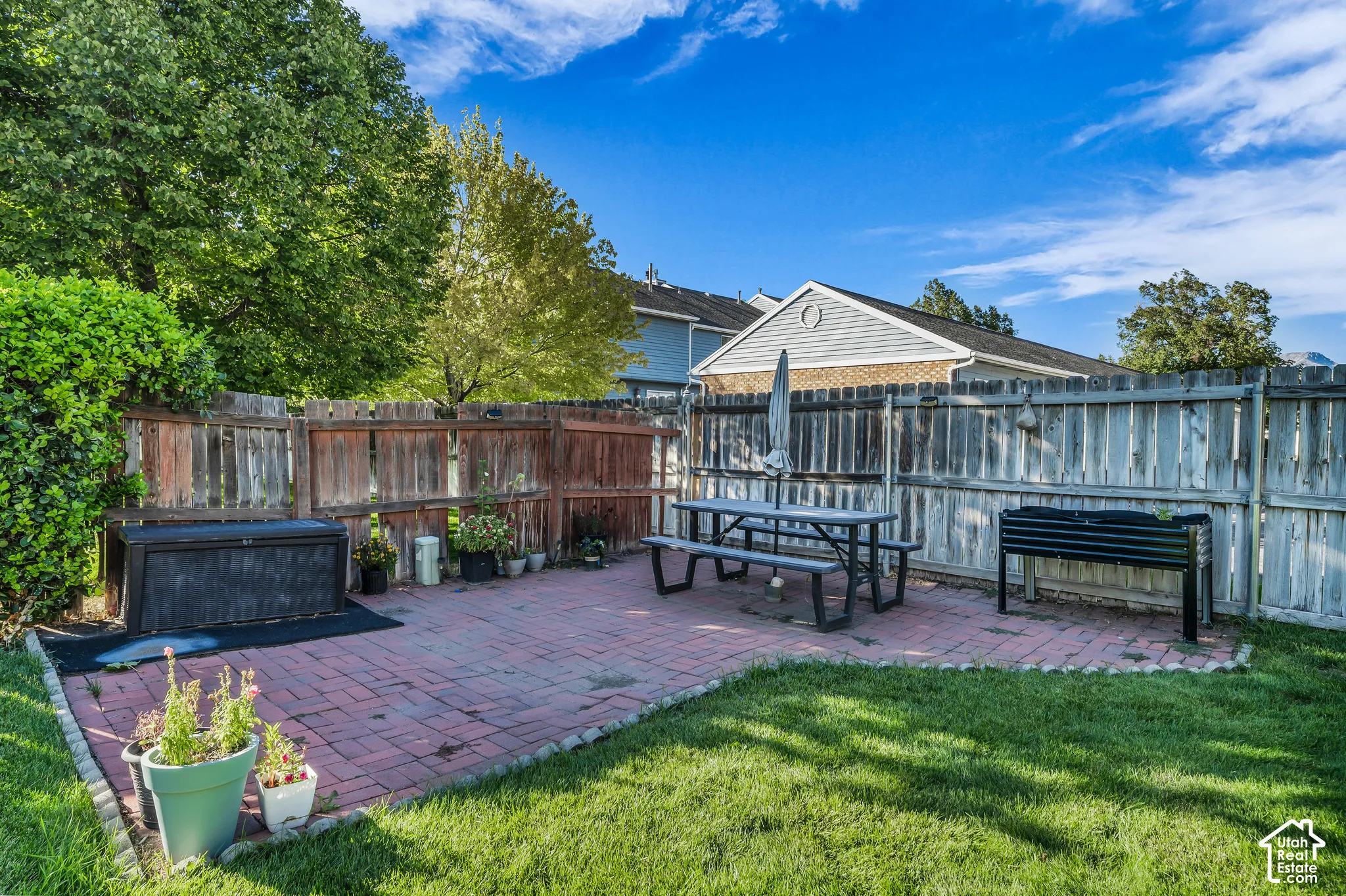 Patio area featuring brick pavers and a manicured lawn