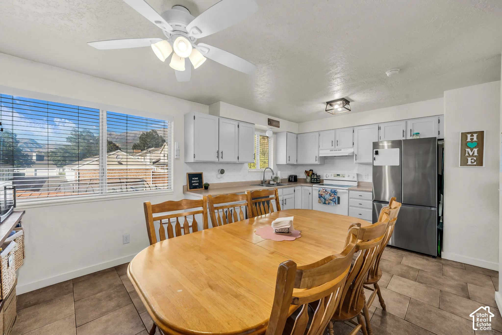 Kitchen with tile flooring, white cabinetry, and ample natural light
