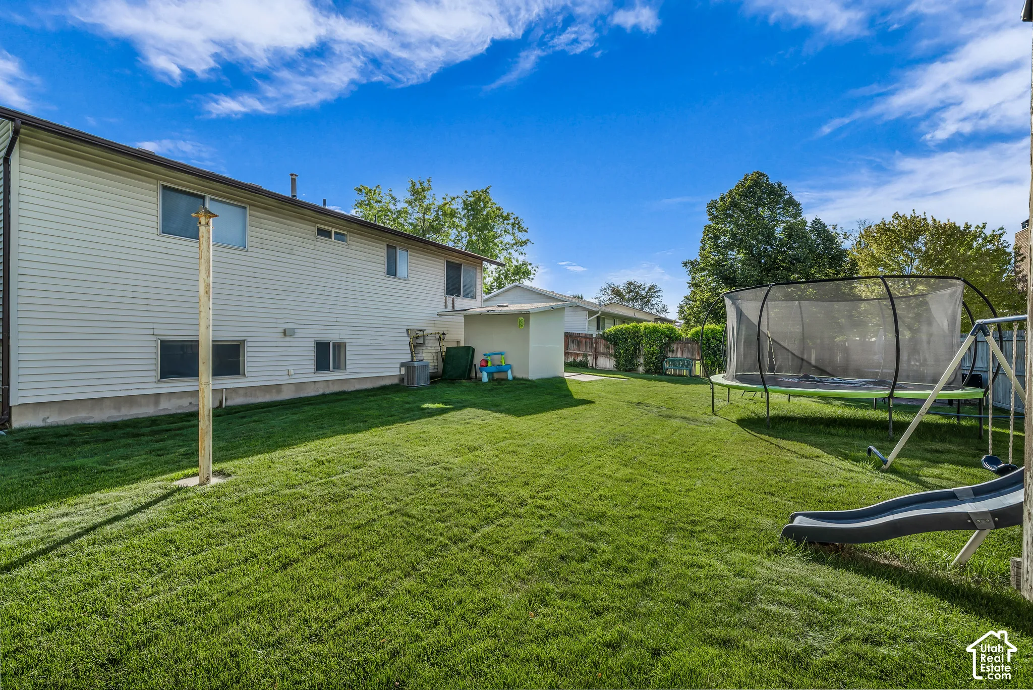 Expansive grassy yard with a storage shed