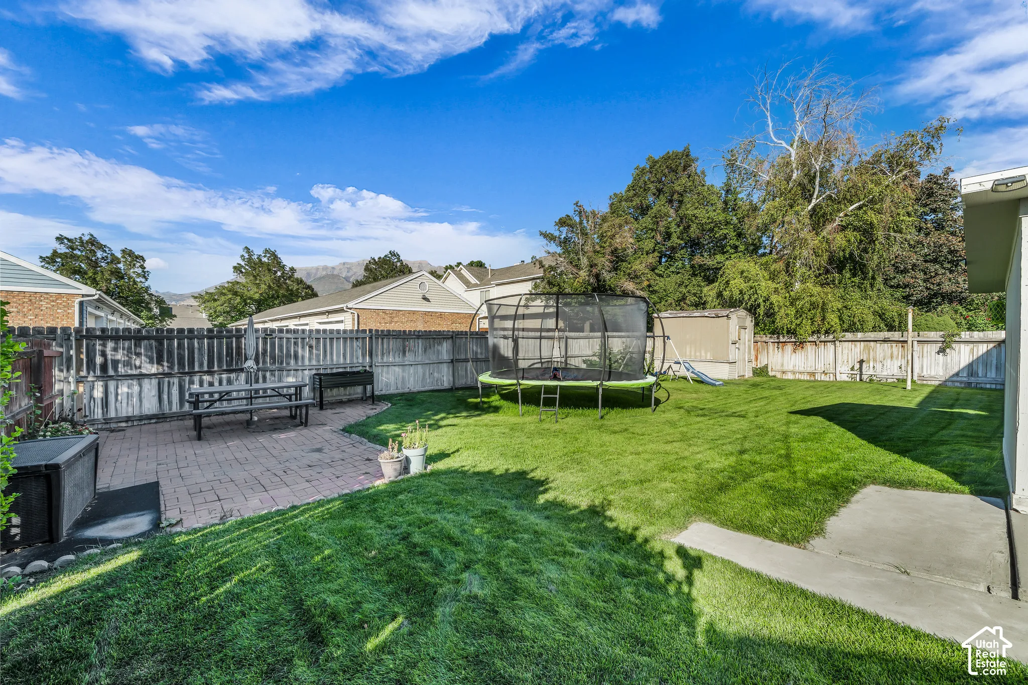 Expansive backyard featuring a manicured lawn and brick paver patio
