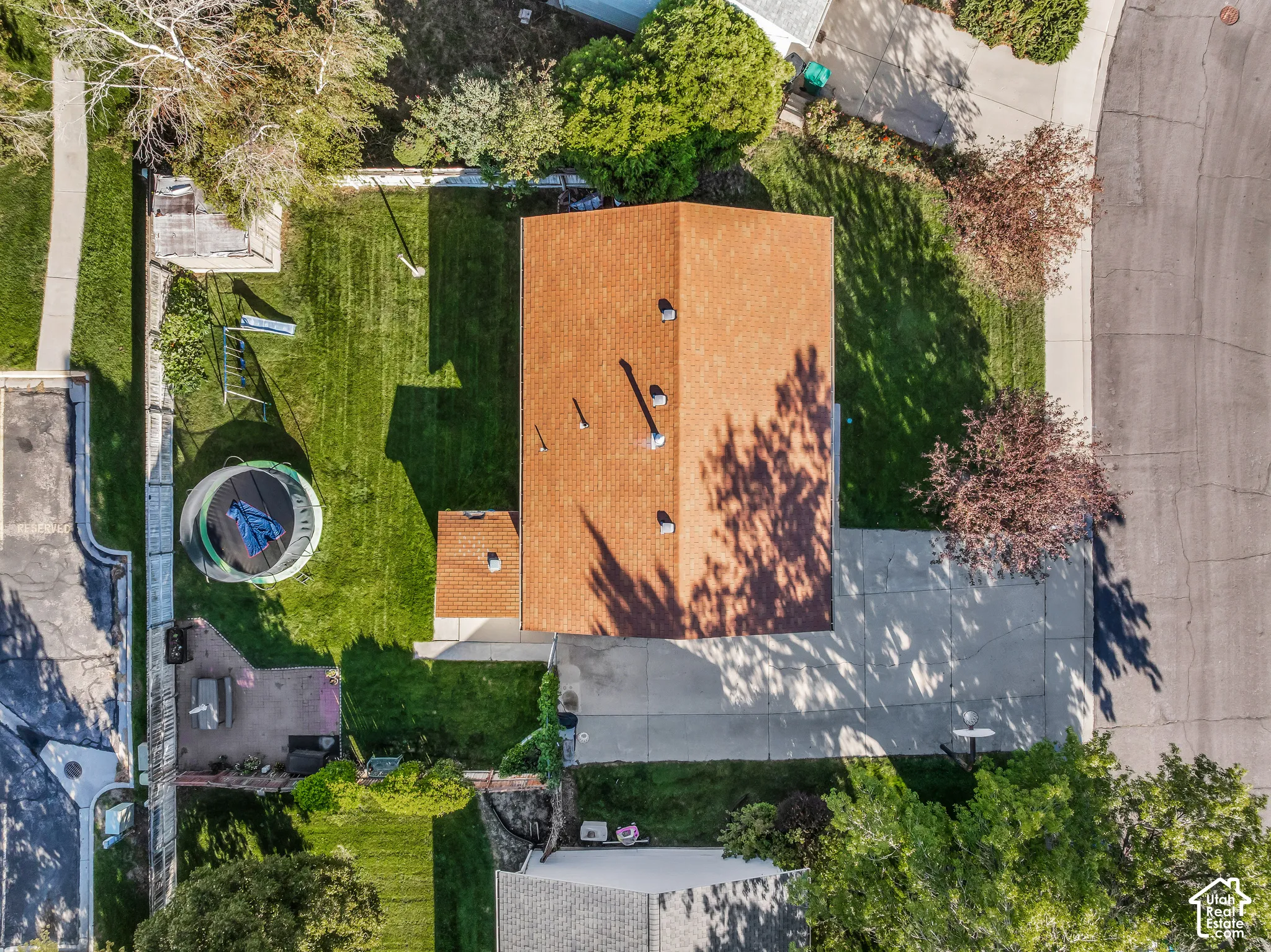 Expansive lot featuring a main residence with an attached structure, a detached outbuilding, a concrete driveway, and a large grass lawn
