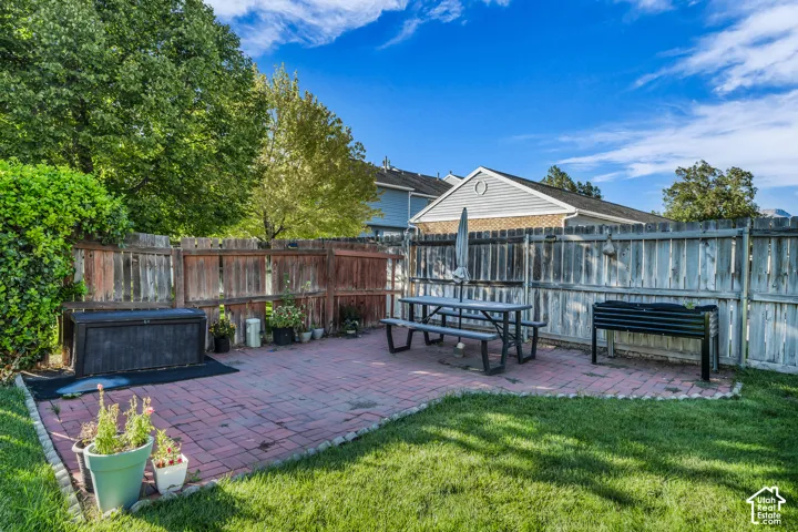 Patio area featuring brick pavers and a manicured lawn