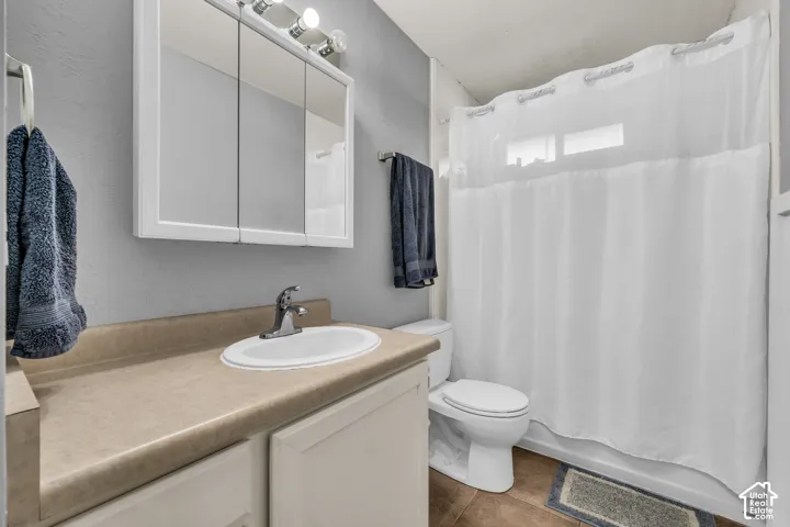 Vanity with an integrated sink, medicine cabinet with mirrored doors, and a shower-tub combination
