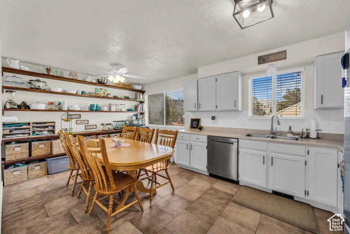 Kitchen featuring white cabinetry, stainless steel dishwasher, and a single basin sink