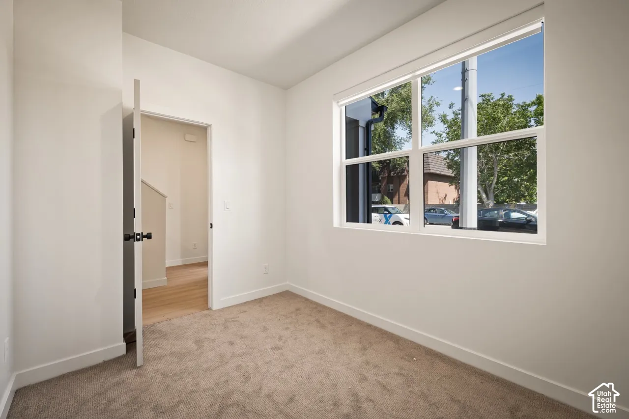 Crisp white walls, neutral carpeting, and a large window with white framing