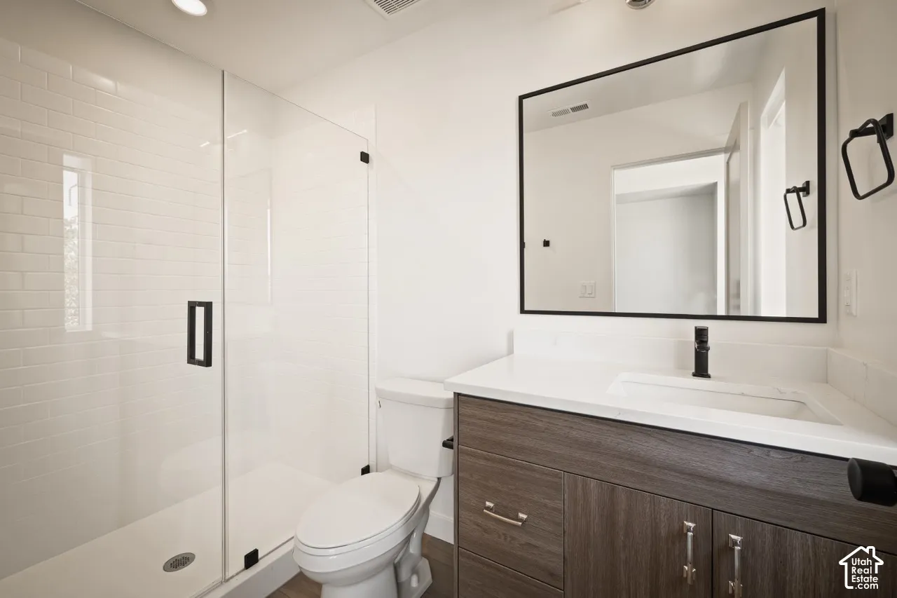 Walk-in shower with clear glass enclosure, subway tile surround, and matte black hardware