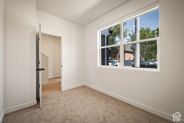 Crisp white walls, neutral carpeting, and a large window with white framing