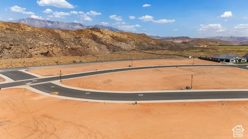 Graded lot with paved streets and utility access, featuring mountain scenery