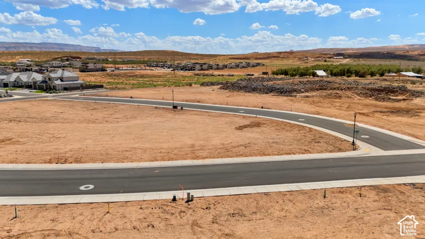 Paved road and curb infrastructure with surrounding undeveloped land
