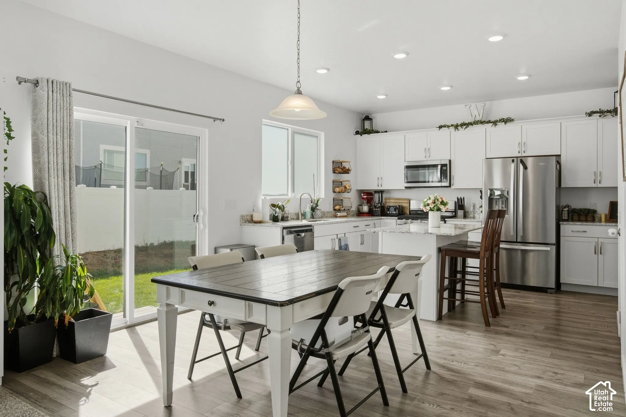 Open-concept kitchen and dining area featuring white cabinetry and stainless steel appliances